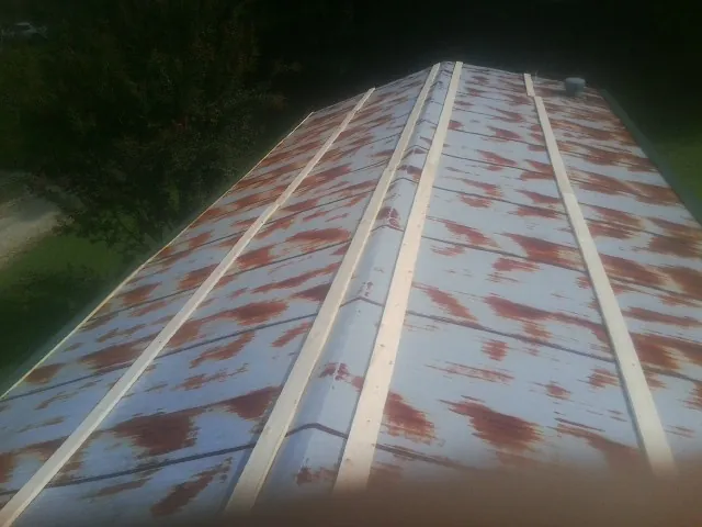 Rusted metal roof panels with new wood purlins before replacement — Storm Damage Roof Repair in Little Neck by Roofing Brothers