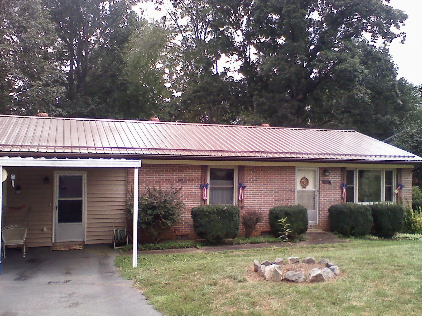 Bronze metal roof and carport on a brick ranch home — Roof Repair work by our crew in Little Neck